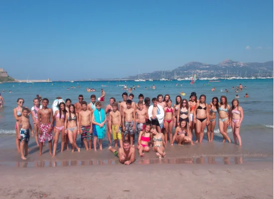 Groupe d'adolescents posant à la plage lors de leur colonie de vacances