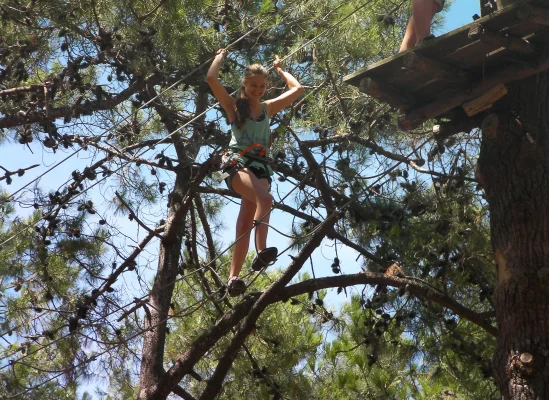 Adolescente souriante pendant un parcours d'acrobranche