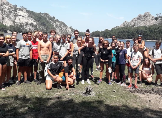 Groupe d'adolescents posant devant un lac lors de leur colo de vacances