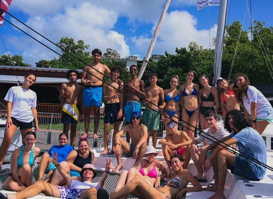 Groupe d'ados posant sur un voilier pendant leur colo en Martinique