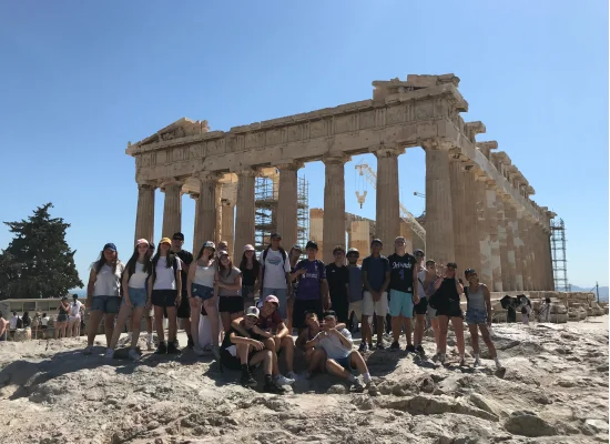 Groupe d'ados devant un monument en Grèce