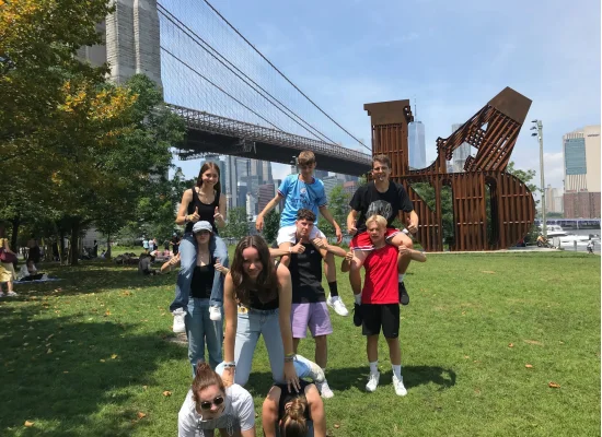 Groupe d'ados posant devant Brooklyn Bridge